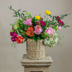 Arreglo Petal Poetry con rosas, hortensias, crisantemos y ruscus en canasta de mimbre, perfecto para el Día de las Madres